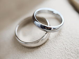 Two wedding bands, one made of white gold and the other of platinum, symbolizing differences in durability and maintenance.