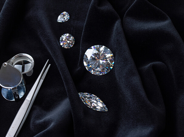 Loose natural diamonds with jeweler’s tools displayed on velvet, representing the diamond appraisal process for collateral loans at Qollateral.