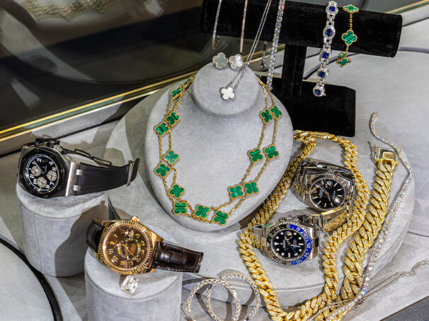 Luxury watches, gold chains, and designer jewelry displayed together to represent the top high-value assets used for collateral loans at Qollateral.