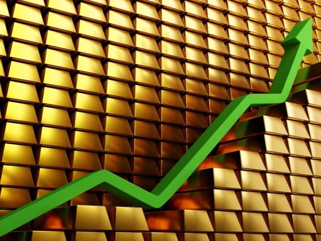 Green upward trend line showing rising gold prices against a background of gold bars.
