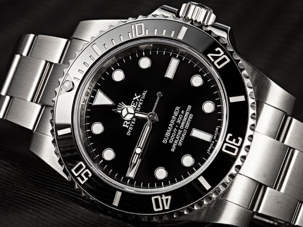 Close-up of a Rolex Submariner watch with a stainless steel band and black dial, showcasing its timeless design and investment potential.