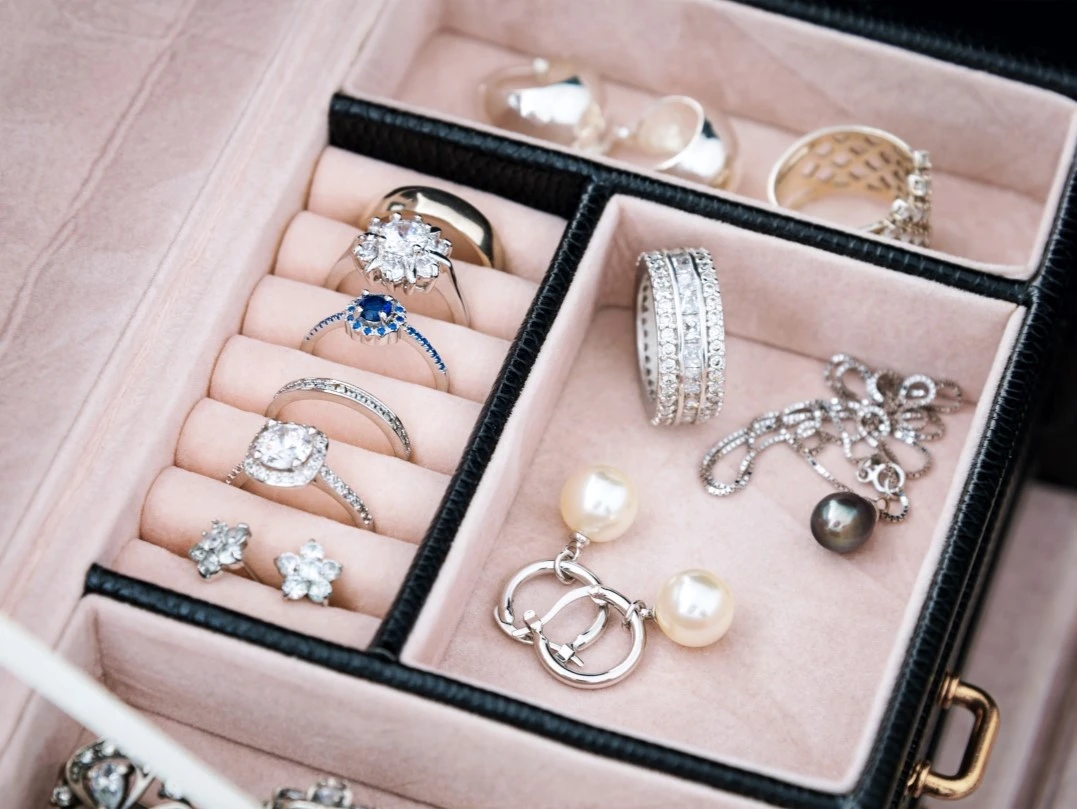 A luxury jewelry box filled with diamond rings, pearl earrings, and gold jewelry, ideal for pawning or selling at Qollateral.