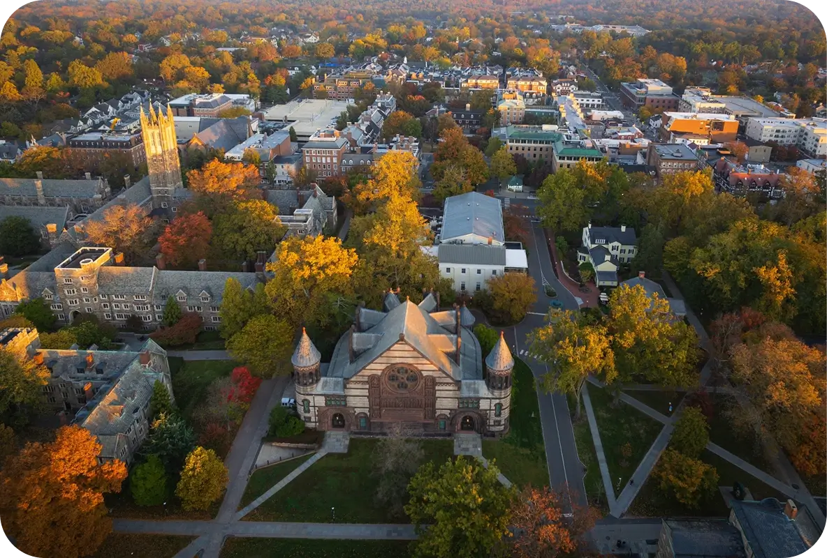 Aerial view of Princeton University campus surrounded by fall foliage and town buildings in Princeton, New Jersey