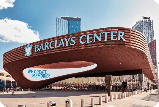 Exterior view of the Barclays Center in Brooklyn with modern architecture and city buildings in the background