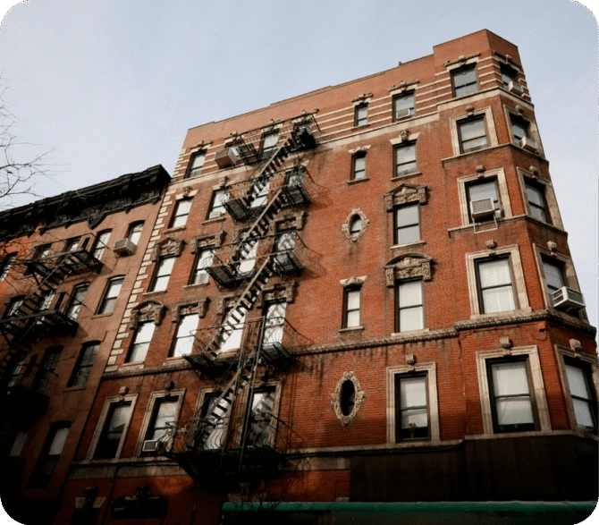 Historic brick apartment buildings in New York City with ornate facades and fire escapes