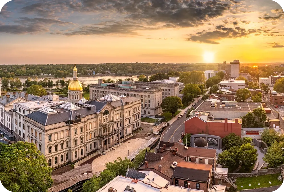 Aerial view of the New Jersey State House in Trenton with a golden dome at sunset
