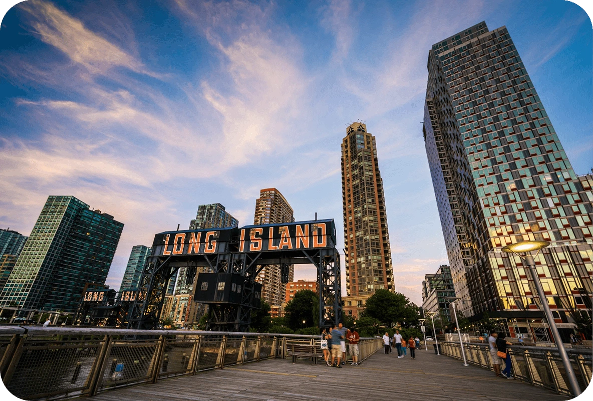 Long Island sign at Gantry Plaza State Park in Queens with modern high-rises at sunset