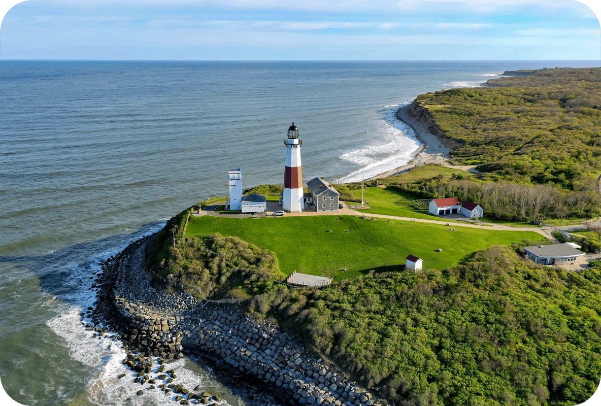Aerial view of the Montauk Point Lighthouse on a cliffside overlooking the Atlantic Ocean