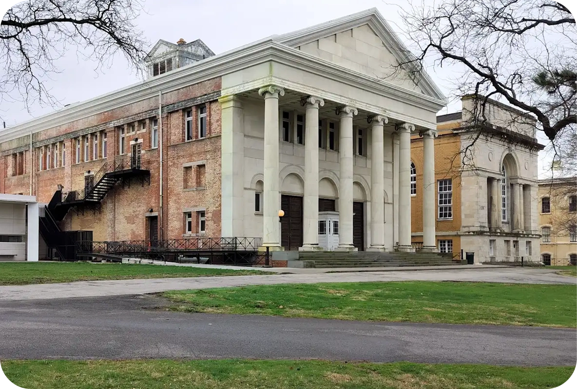 Exterior of the Staten Island Museum building with classical columns and banners displayed on a clear day