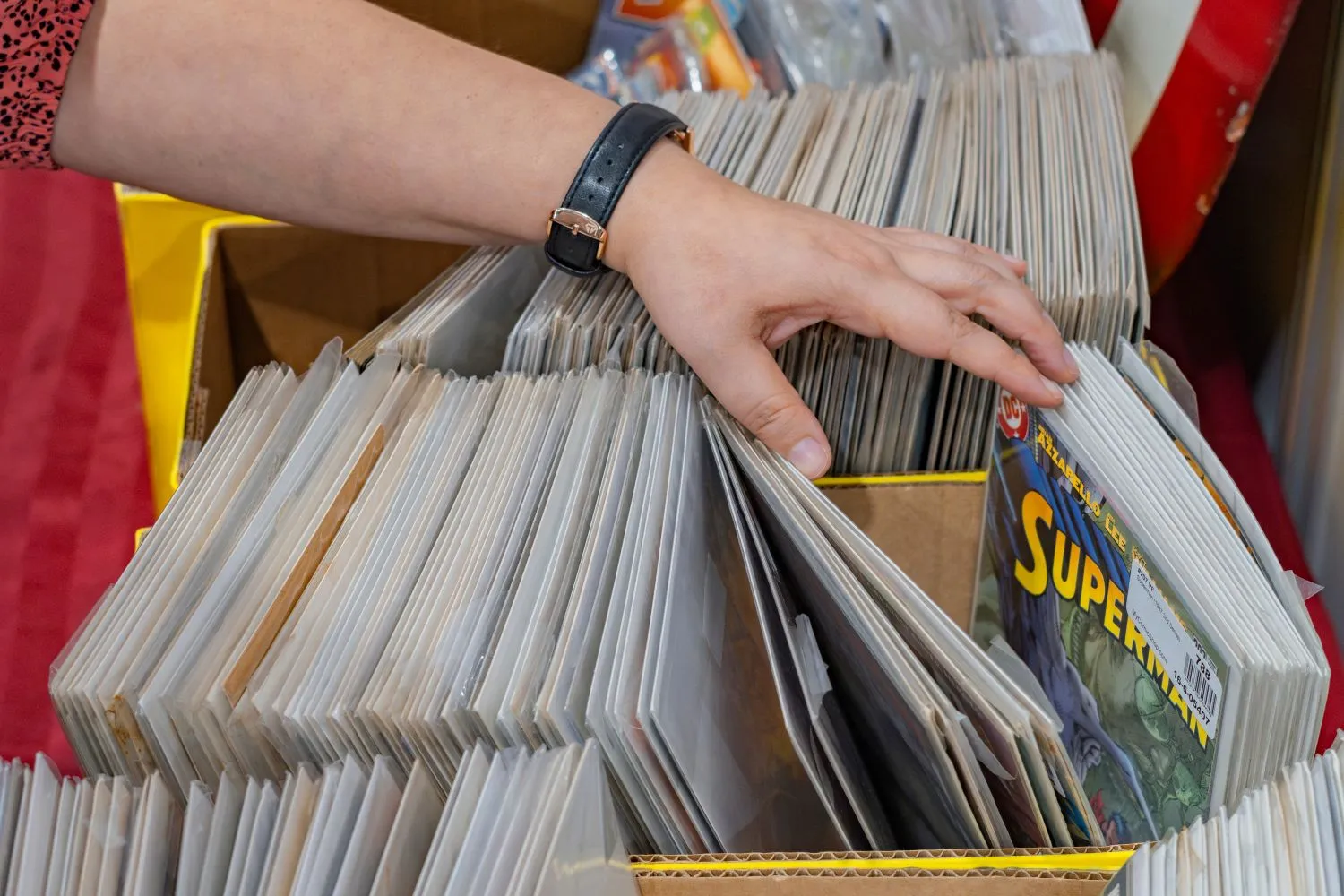 Collector examining comic books during a professional appraisal for loan value.