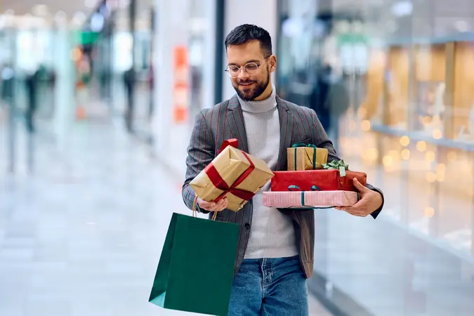 Man holding holiday gifts while shopping, representing how same-day watch loans from Qollateral provide fast cash for Black Friday and Cyber Monday deals.