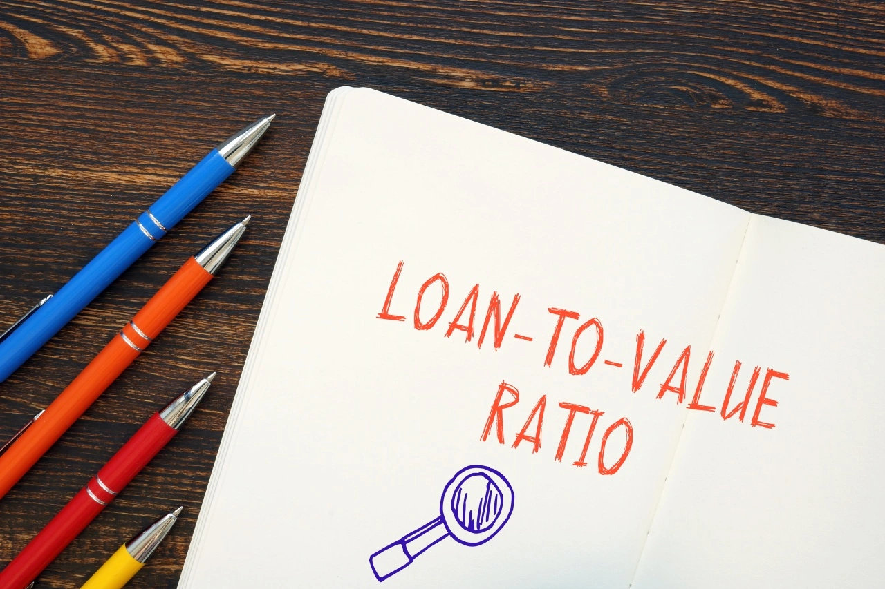 Loan-to-value ratio written in notebook with pens representing collateral lending concept