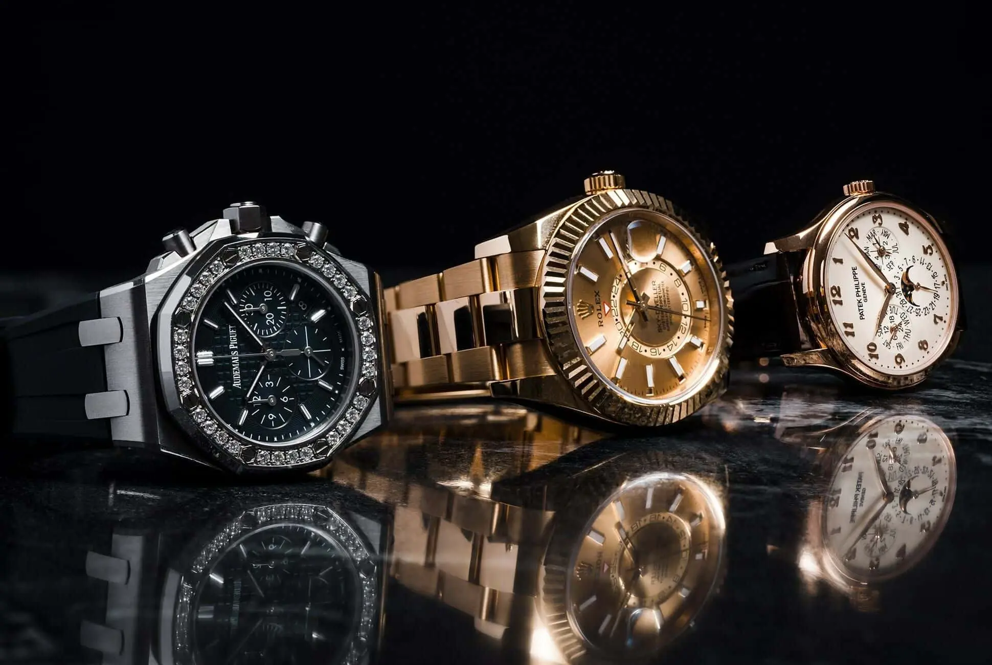 Audemars Piguet Royal Oak, Rolex Sky-Dweller, and Patek Philippe luxury watches displayed on a dark reflective surface